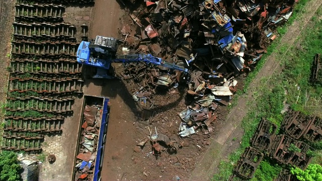 在垃圾场忙了一天。机械爪掉落金属碎片。鸟瞰图视频素材