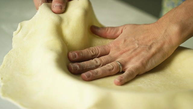 一个女人的手在一个馅饼盘里形成一个扁平的面团准备填馅视频下载