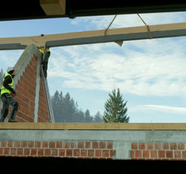 LD Crane将一根木梁举在空中，这样建筑工人们就可以将它放置到位视频素材