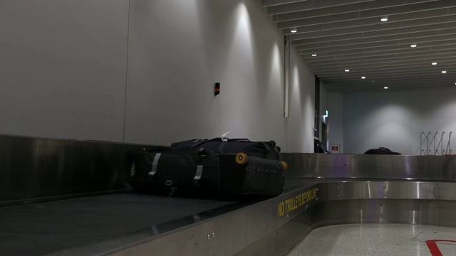 在机场行李提取处，行李通过传送带传送。视频下载