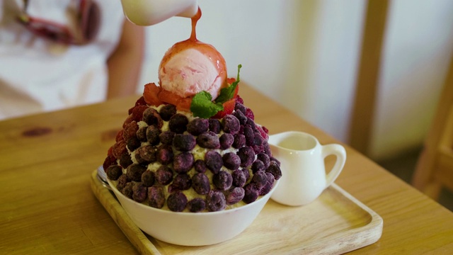将草莓酱倒入混合水果浆果冰苏或冰苏，韩式刨冰甜点与甜配料视频素材