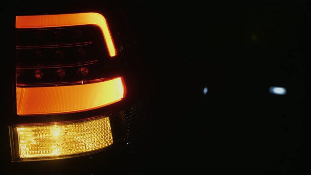 汽车尾灯在黑暗的背景下闪烁视频下载
