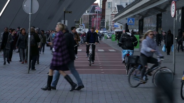 2018年9月18日，荷兰阿姆斯特丹。人们在阿姆斯特丹老城中心繁忙的街道上骑自行车。视频素材