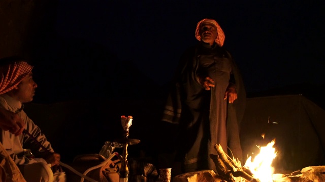 扎拉比亚贝都因人讲故事和唱当地民间歌曲围绕篝火在瓦迪拉姆沙漠视频下载