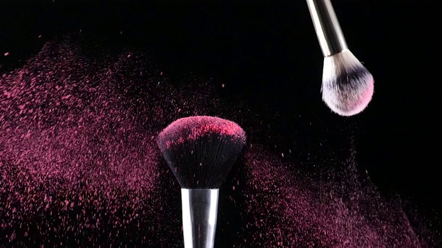 两个化妆刷碰撞后产生的彩色粉末爆炸视频素材