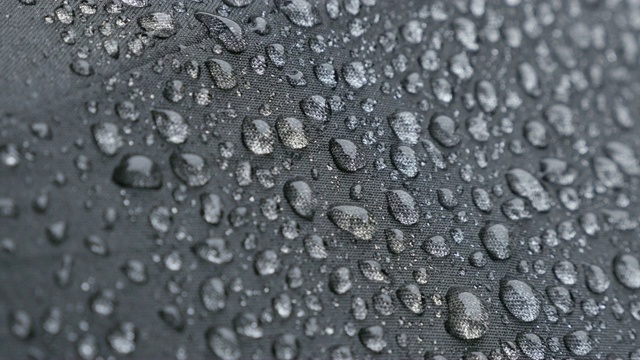 小雨滴覆盖在暗伞表面4K 2160p 30fps超高清镜头-雨天防水织物保护表面的特写视频下载