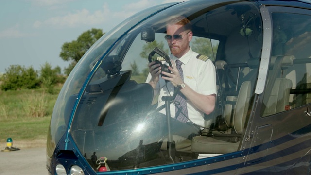 直升机飞行员在驾驶舱里戴着耳机视频素材