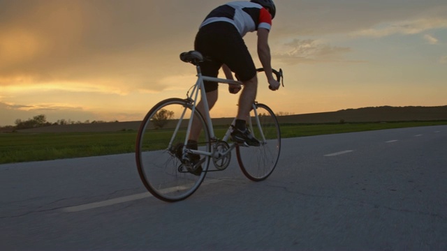 MS男性自行车骑在农村日落路视频下载