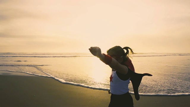 年轻的超级英雄女孩在加州海滩上跑步视频素材