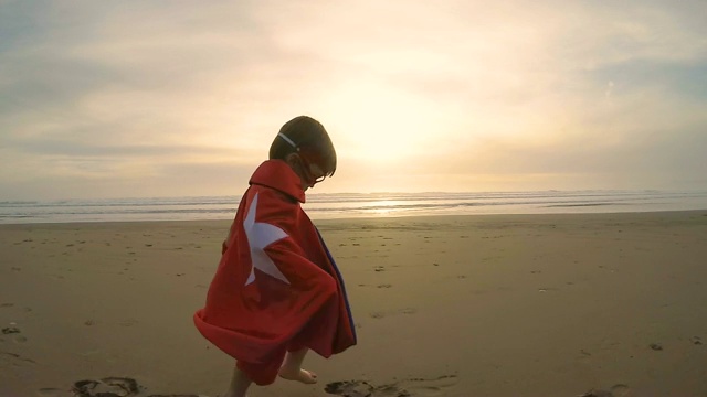 小男孩超级英雄在加州海滩上跑步视频素材
