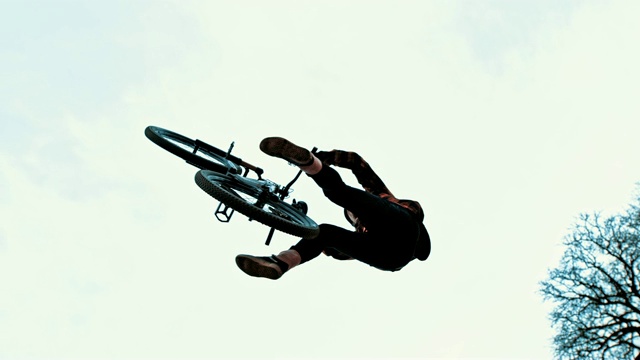 MS Young man在多云的天空下翻转BMX自行车视频素材