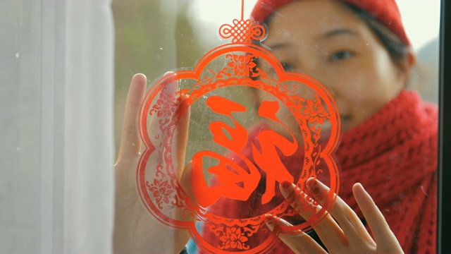 妇女把中国传统剪纸贴在窗户上视频购买