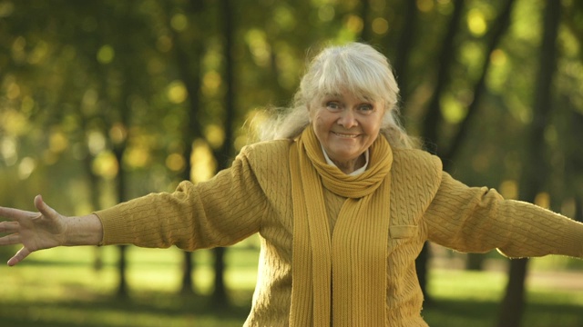 快乐的老女人在公园里扔钞票，计划退休视频素材