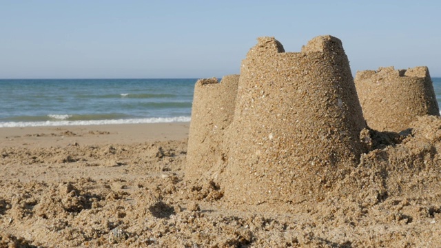 沙滩上的沙堡在夏天放松的慢速背景1920X1080全高清镜头-在蓝色海浪水附近的沙塔的慢动作1080p高清视频视频素材