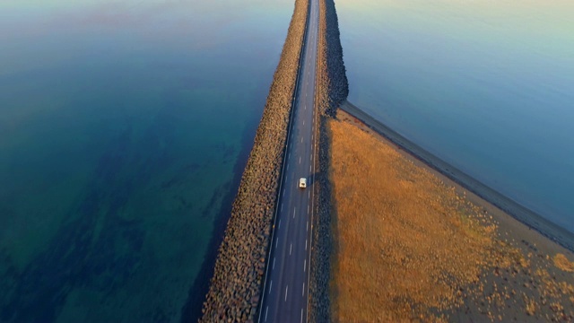 WS鸟瞰图汽车沿着道路越过遥远的山湖，冰岛视频下载
