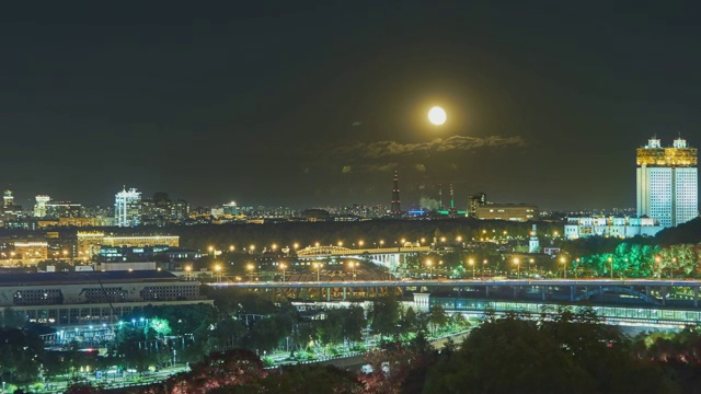 一颗月亮在夜晚升起在城市上空的影像视频素材