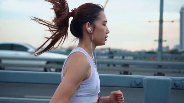 年轻女子慢跑过桥的慢镜头视频素材