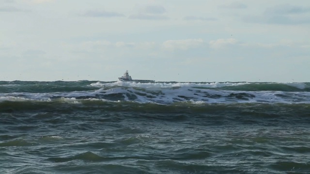 船在海上暴风中航行。大风把水滴吹出水面。视频素材