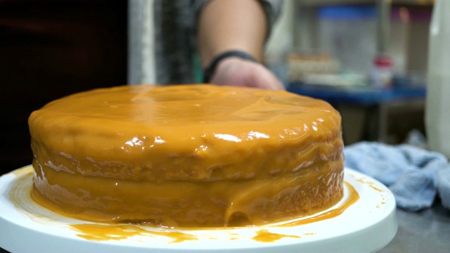 中景专业面包师霜和旋转泰国茶味蛋糕与蛋糕转盘在厨房-亚洲食谱蛋糕视频下载