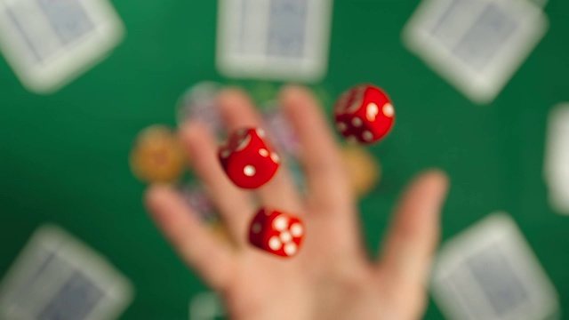 慢动作:三个红色的骰子被抛和抓住在一个桌子-顶视图视频下载
