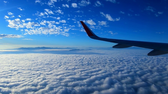 飞机飞行时多云和蓝天的鸟瞰图视频素材