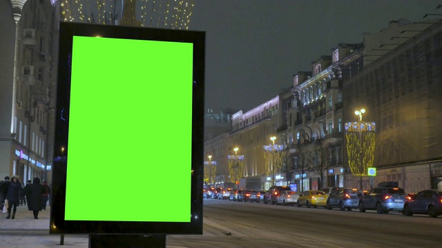 街道上有一块绿色屏幕的大广告牌为节日装饰。视频素材