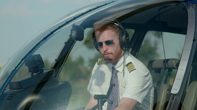 直升机飞行员戴耳机检查飞行仪器视频素材
