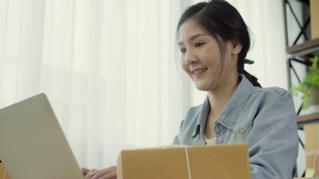 美丽聪明的亚洲年轻企业家女企业家企业主的中小企业在线检查产品的库存和保存到电脑在家里工作。小企业主在家办公的概念。视频素材