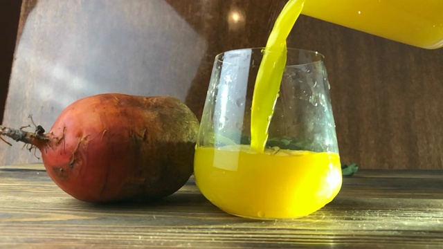 桌上玻璃杯里的黄色甜菜汁视频素材