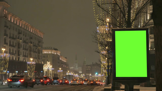 街道上有一块绿色屏幕的大广告牌为节日装饰。视频素材
