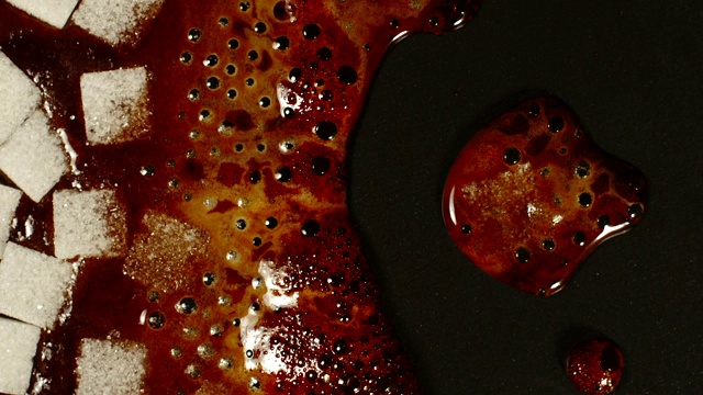 俯视图:方糖在黑色平底锅上沸腾视频下载