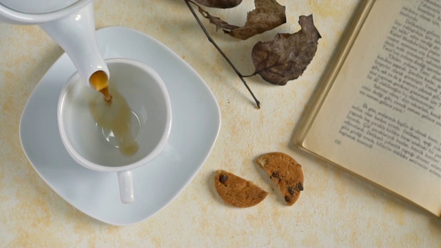 饼干和一杯茶在木制背景，慢动作。视频素材