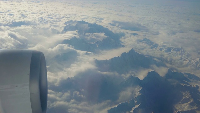 从喷气式飞机上俯瞰瑞士阿尔卑斯山。一个大引擎清晰可见视频素材