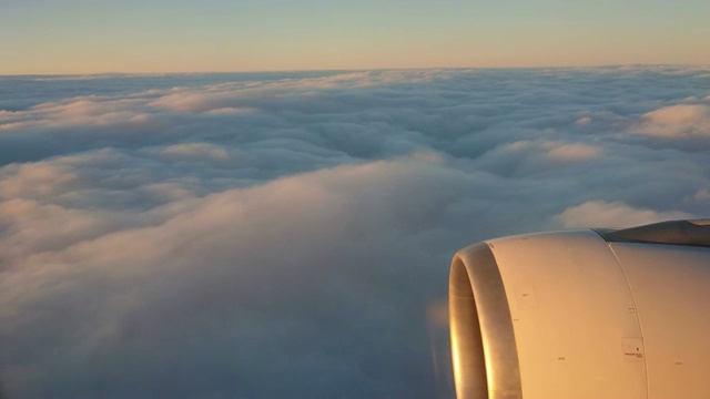 在喷气式飞机上从云层上方俯瞰的景色。其中一个大引擎清晰可见视频素材
