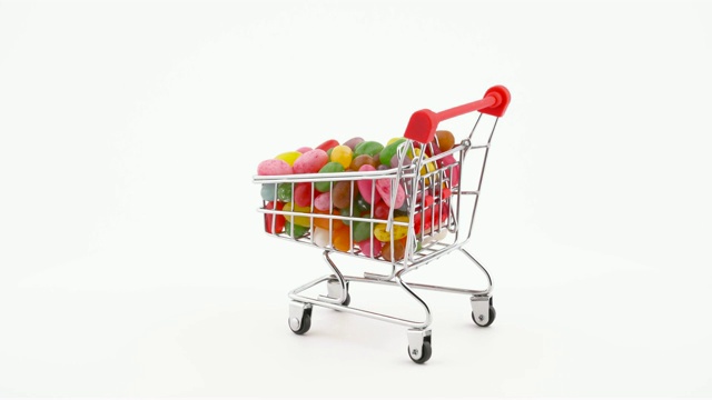 购物车装满了生动的果冻糖豆在转盘上旋转。孤立在白色背景上。特写镜头。视频下载