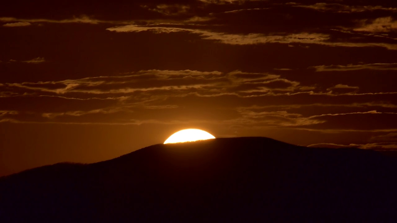 时间流逝，日落在一座山与五颜六色的橙色云彩视频下载