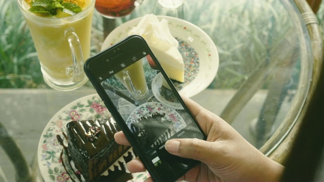 女性用智能手机拍摄食物视频下载