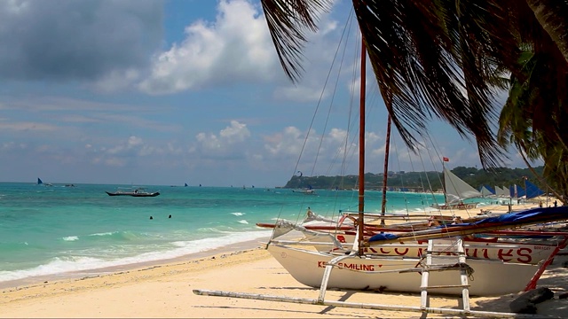菲律宾长滩上的船只在热带的白色沙滩上，海浪和云视频下载