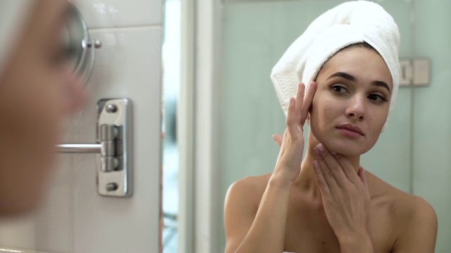 面部皮肤护理。在浴室里擦护肤霜的女人视频购买