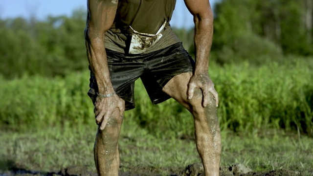 成年男性在泥浆跑期间强烈地盯着视频下载
