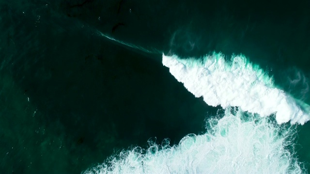 从上到下的鸟瞰图，巨大的海浪撞击在阳光明媚的一天视频素材