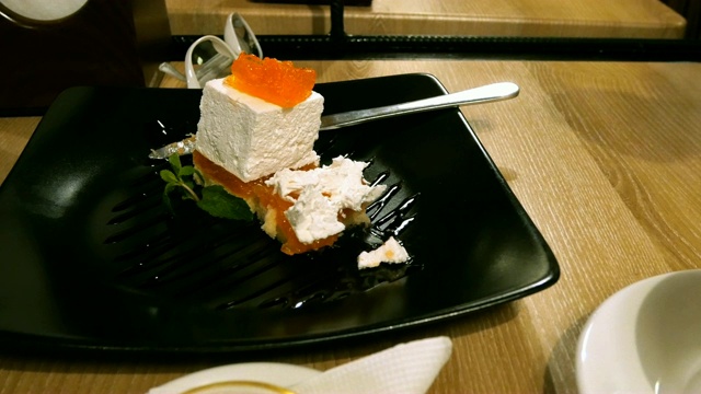 女人在咖啡馆或餐馆吃蛋糕，用勺子把它拿起来。视频素材
