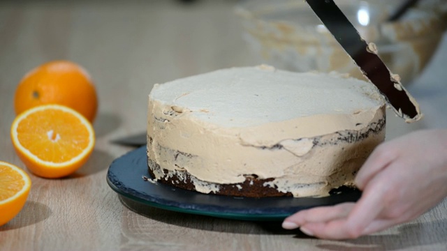 糖果师傅把奶油放在蛋糕上面。面包师用奶油糖霜使蛋糕光滑视频素材