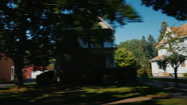 沿着典型的美国郊区骑行。从车窗你可以看到木屋和整洁的草坪视频素材