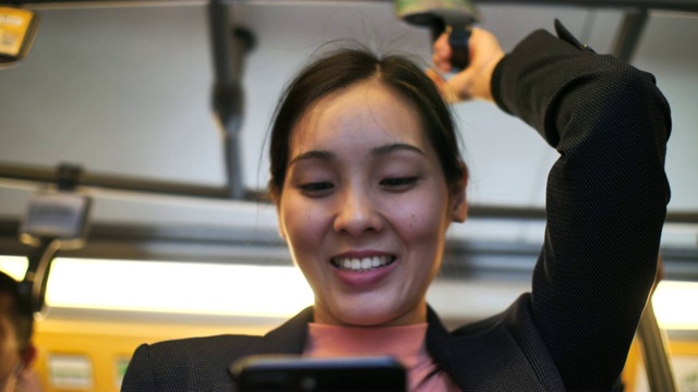 年轻女子使用手机在地铁看智能手机视频素材