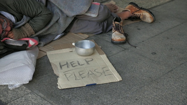 一个穿着脏衣服睡在街上寻求帮助的无家可归的老人视频下载