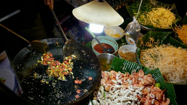 一名泰国男子在夜市上做饭视频素材