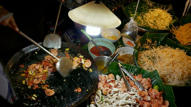 一名泰国男子在夜市上做饭视频素材