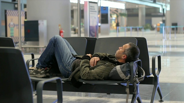 一个年轻人在机场候机厅候机时睡着了视频下载