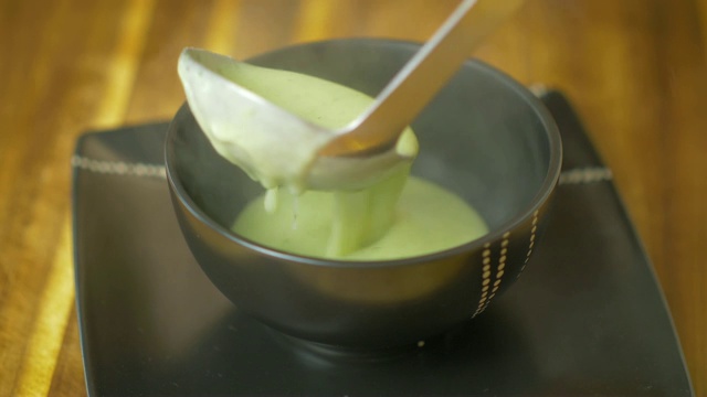 将花椰菜汤倒入黑色的碗中视频下载